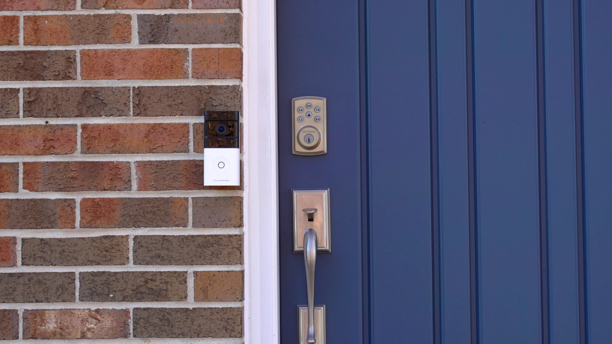 Alarm.com ADC-VDB780B battery doorbell installed beside a blue entry door