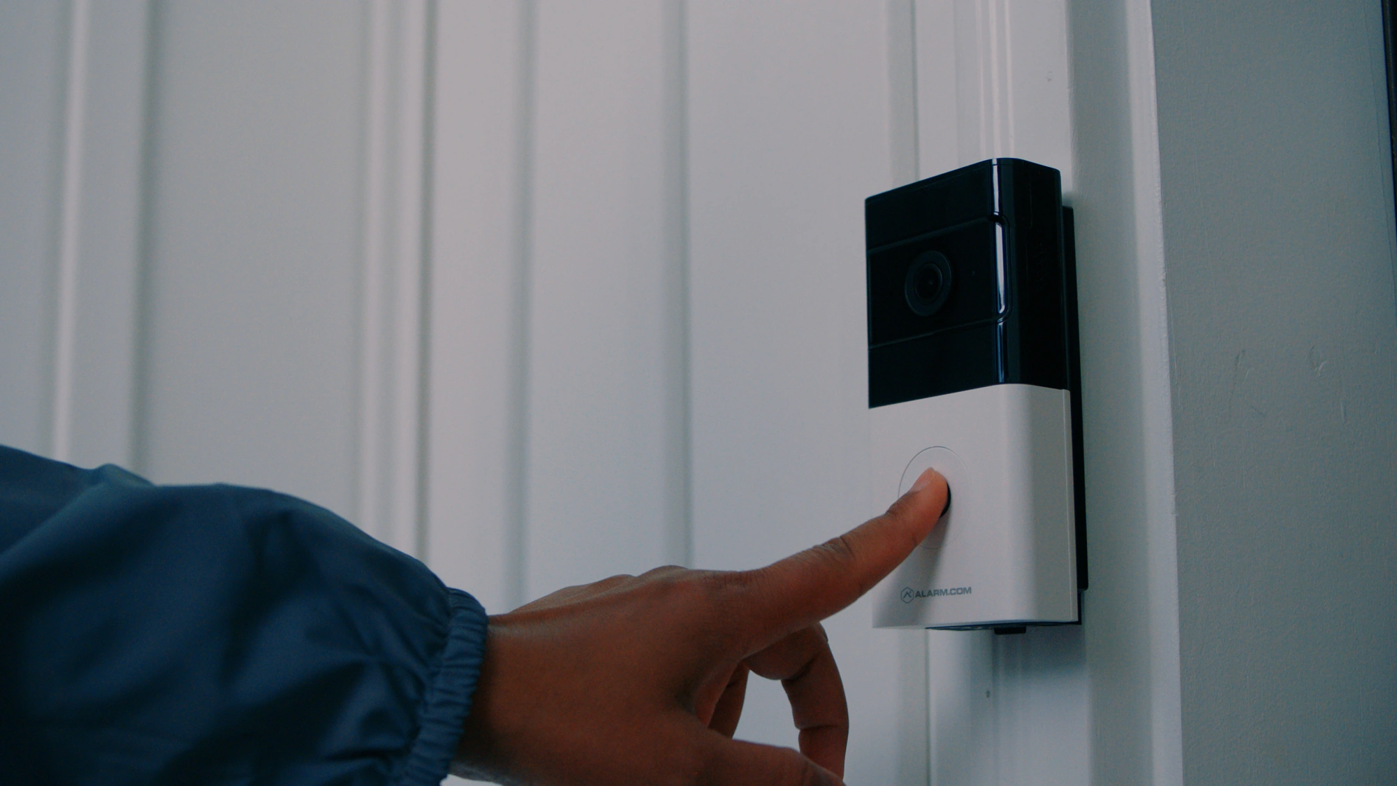 Close view of a visitor using the Alarm.com ADC-VDB780B battery doorbell