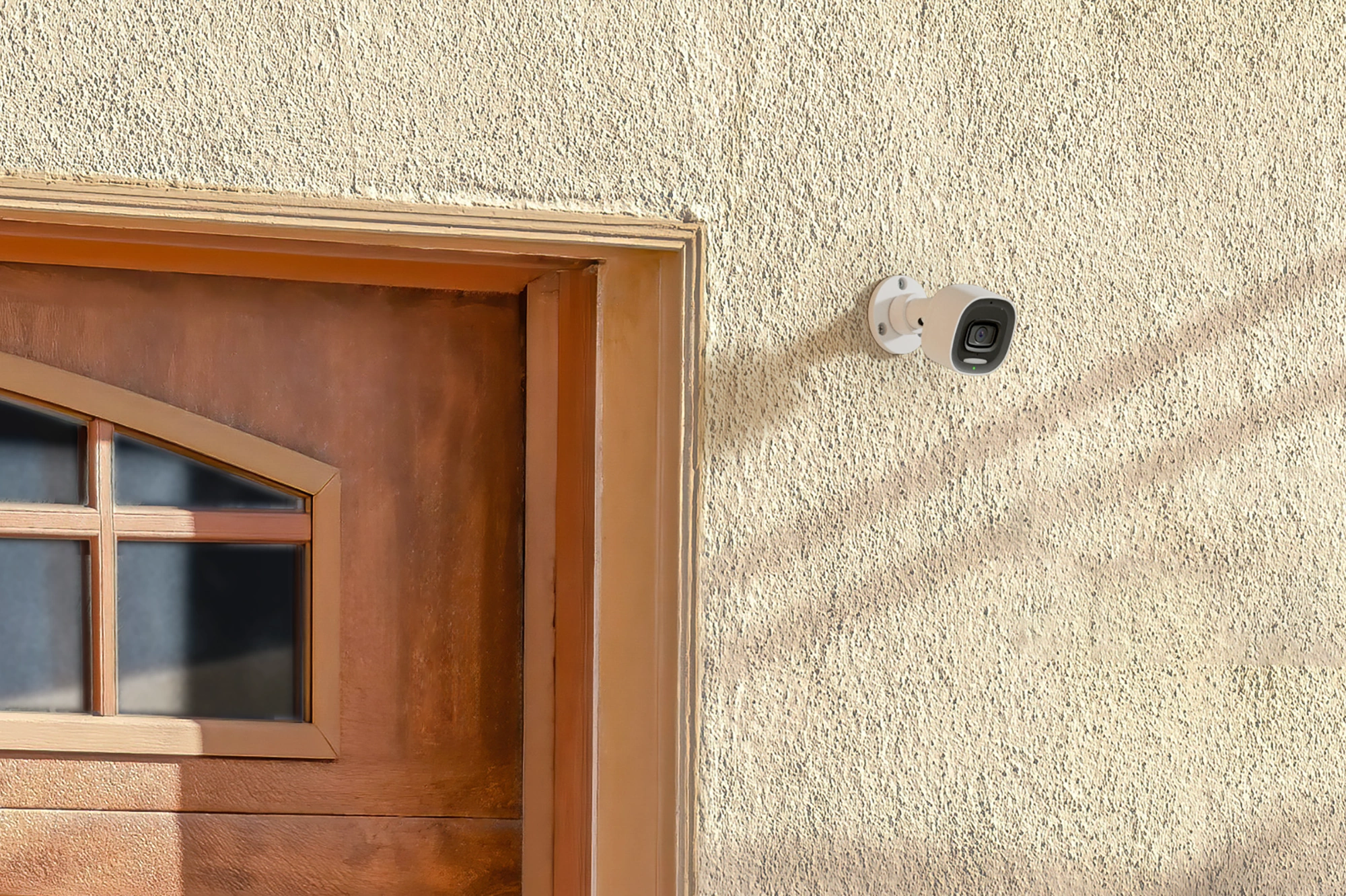 Alarm.com ADC-VC730P spotlight camera installed beside an exterior entry