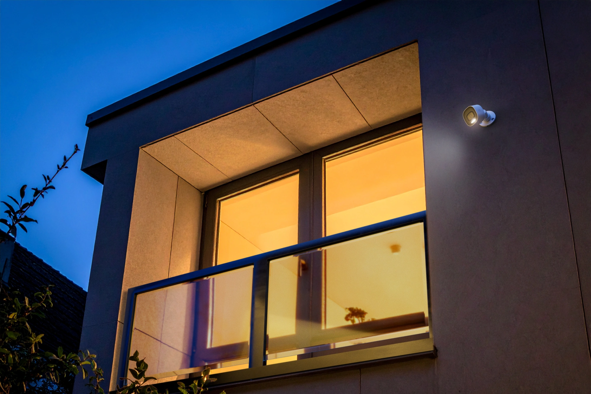 Alarm.com ADC-VC730P spotlight camera illuminating an exterior at night