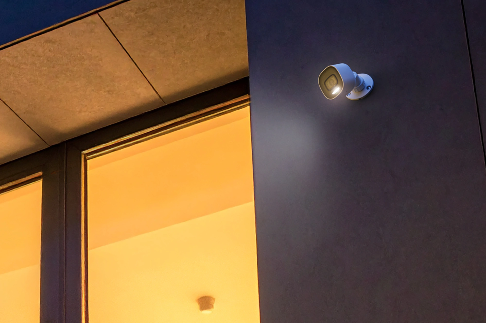 Close view of an Alarm.com ADC-VC730P camera with spotlight active at night
